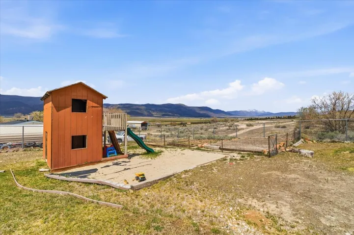 Outdoor play structure with a built-in slide and sandpit