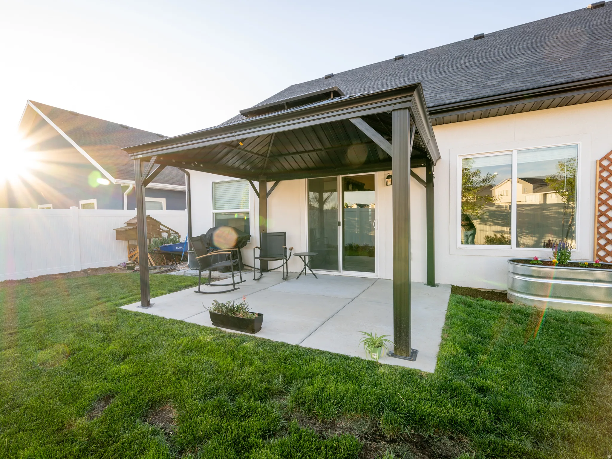 Expansive patio featuring a permanent pergola structure, concrete paving, and a sliding glass door entry