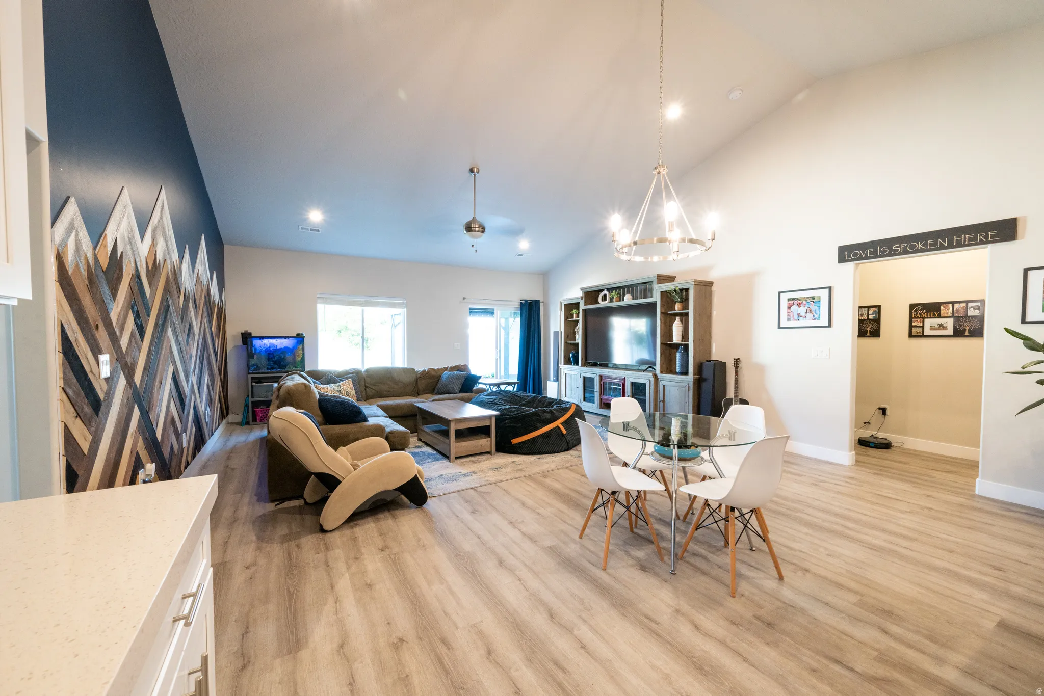 Open-concept living area featuring a vaulted ceiling and wood-finish flooring