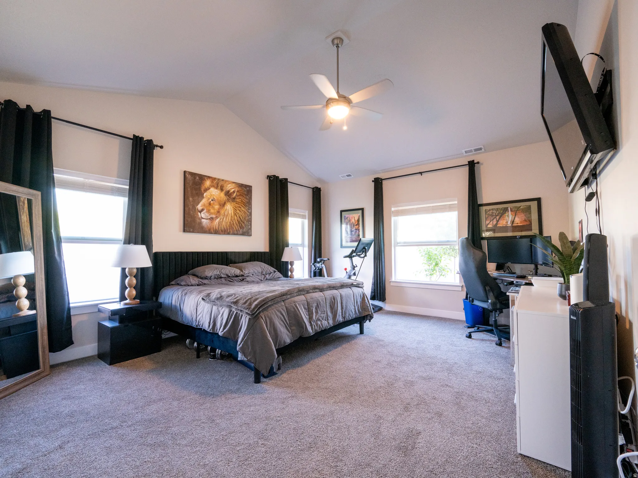 Spacious room featuring vaulted ceilings, recessed lighting, and a ceiling fan