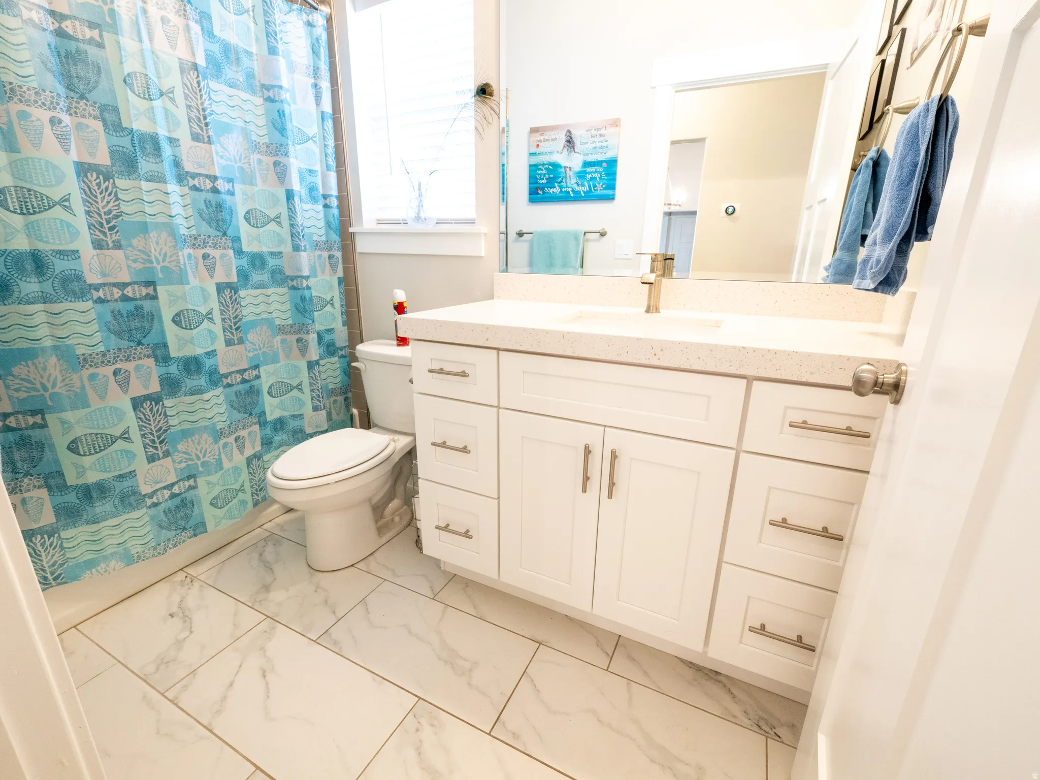 Dual-sink vanity featuring a light-toned countertop and white cabinetry