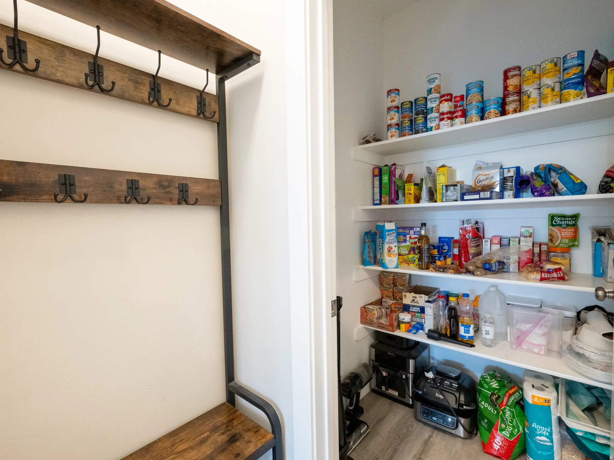 Built-in hall tree with a wood-finish bench, shelving, and multiple metal hooks