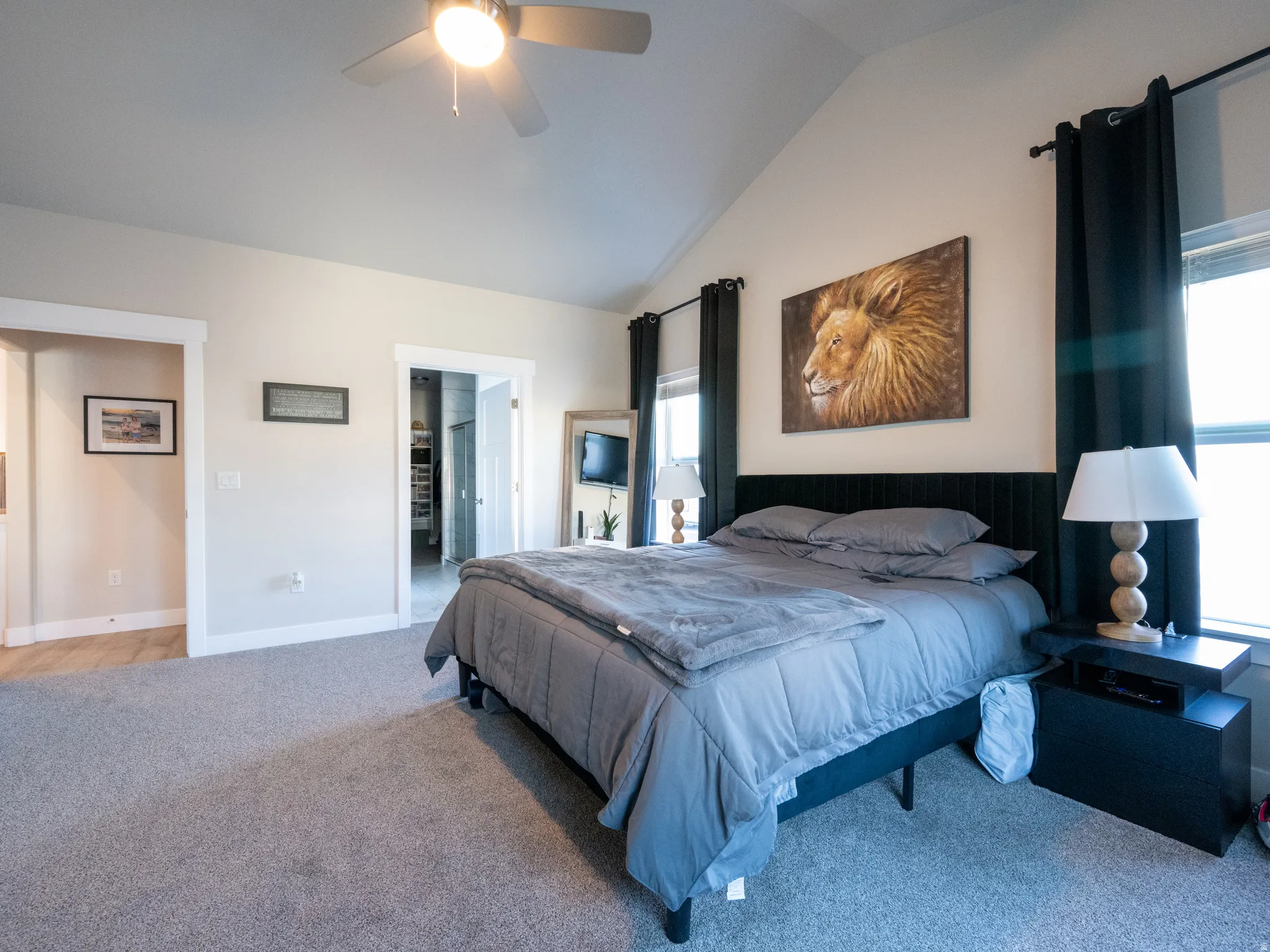 Bedroom featuring a vaulted ceiling with a ceiling fan, light gray carpet, and white trim