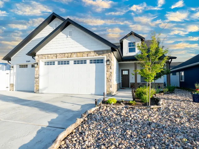 Contemporary residence featuring white horizontal siding and natural stone accents