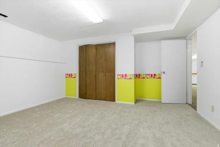Carpeted room with white walls and a bright accent wall