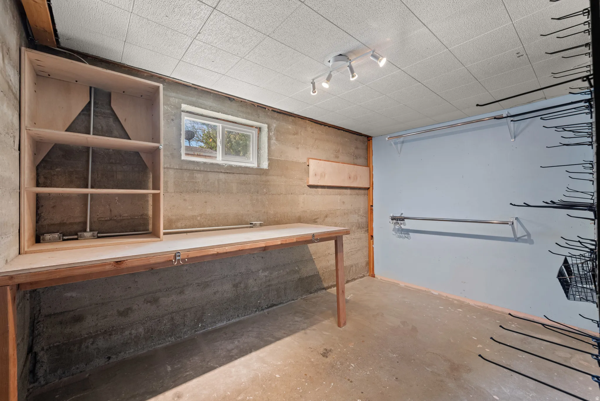 Utility space featuring a built-in wooden workbench, integrated shelving, and a single window