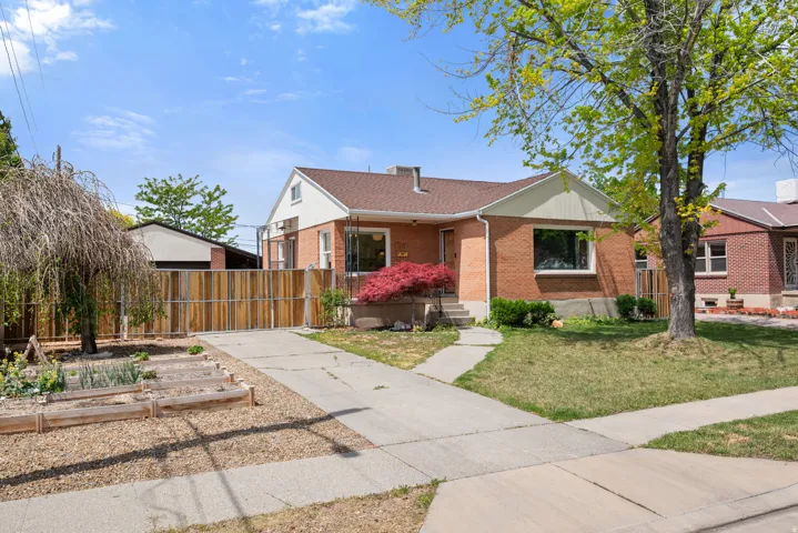 Brick exterior featuring a brown roof and white trim