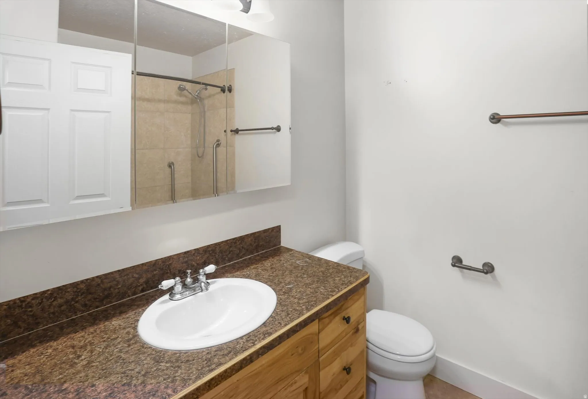 Bathroom vanity with an integrated sink, brown speckled countertop, and wood-finish cabinetry