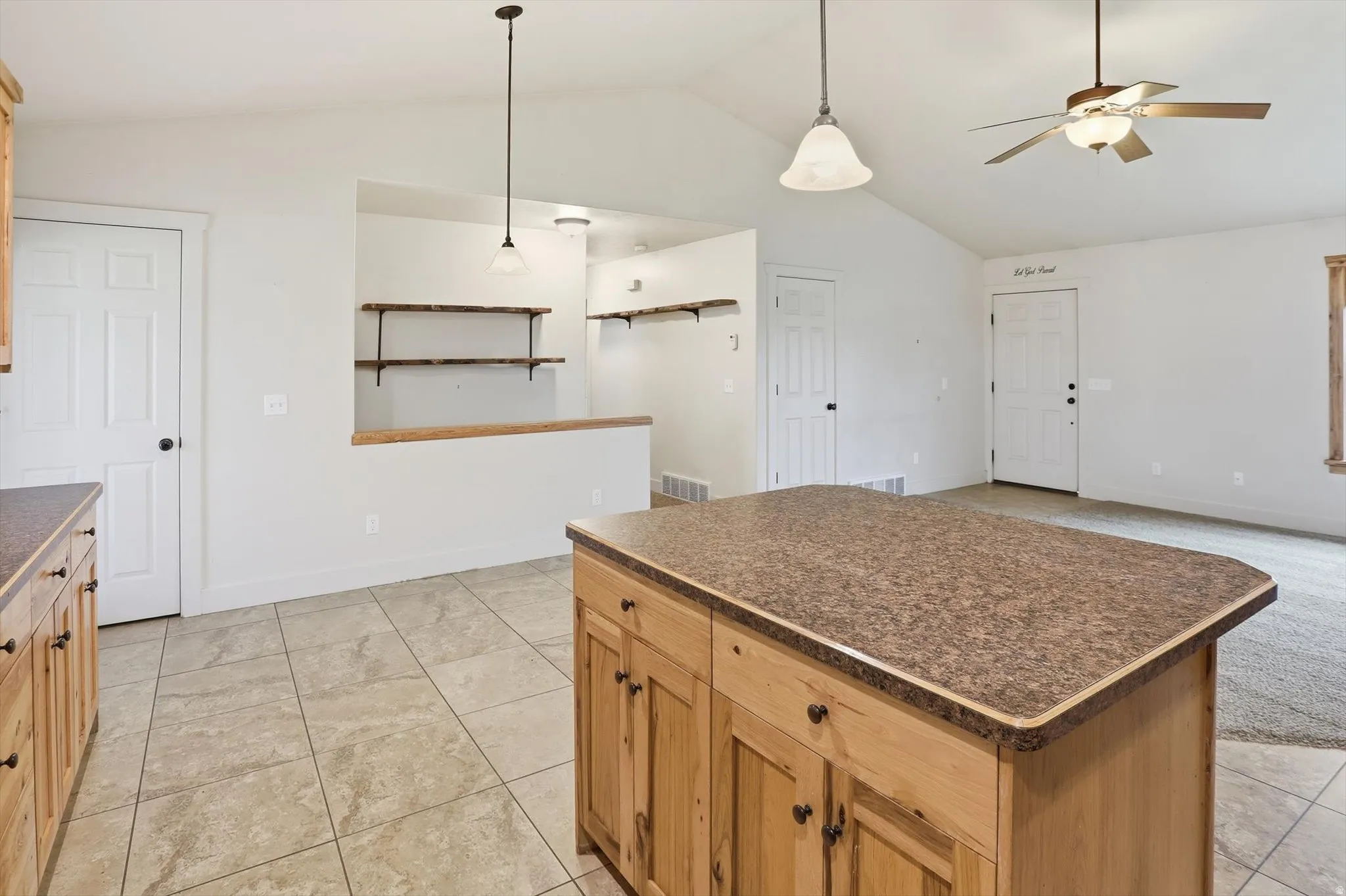 Central kitchen island with a speckled countertop and wood cabinetry