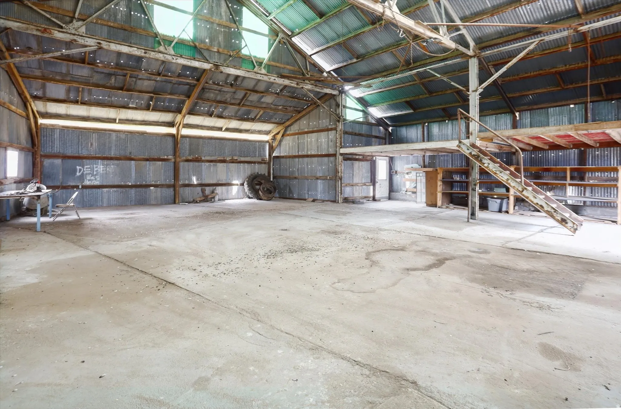 Spacious interior with concrete flooring and corrugated metal walls