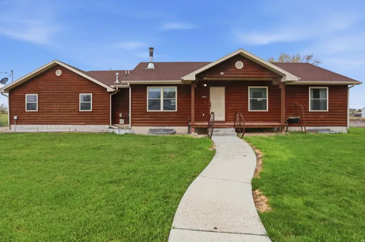 Single-story residence featuring wood-look siding and a brown shingle roof