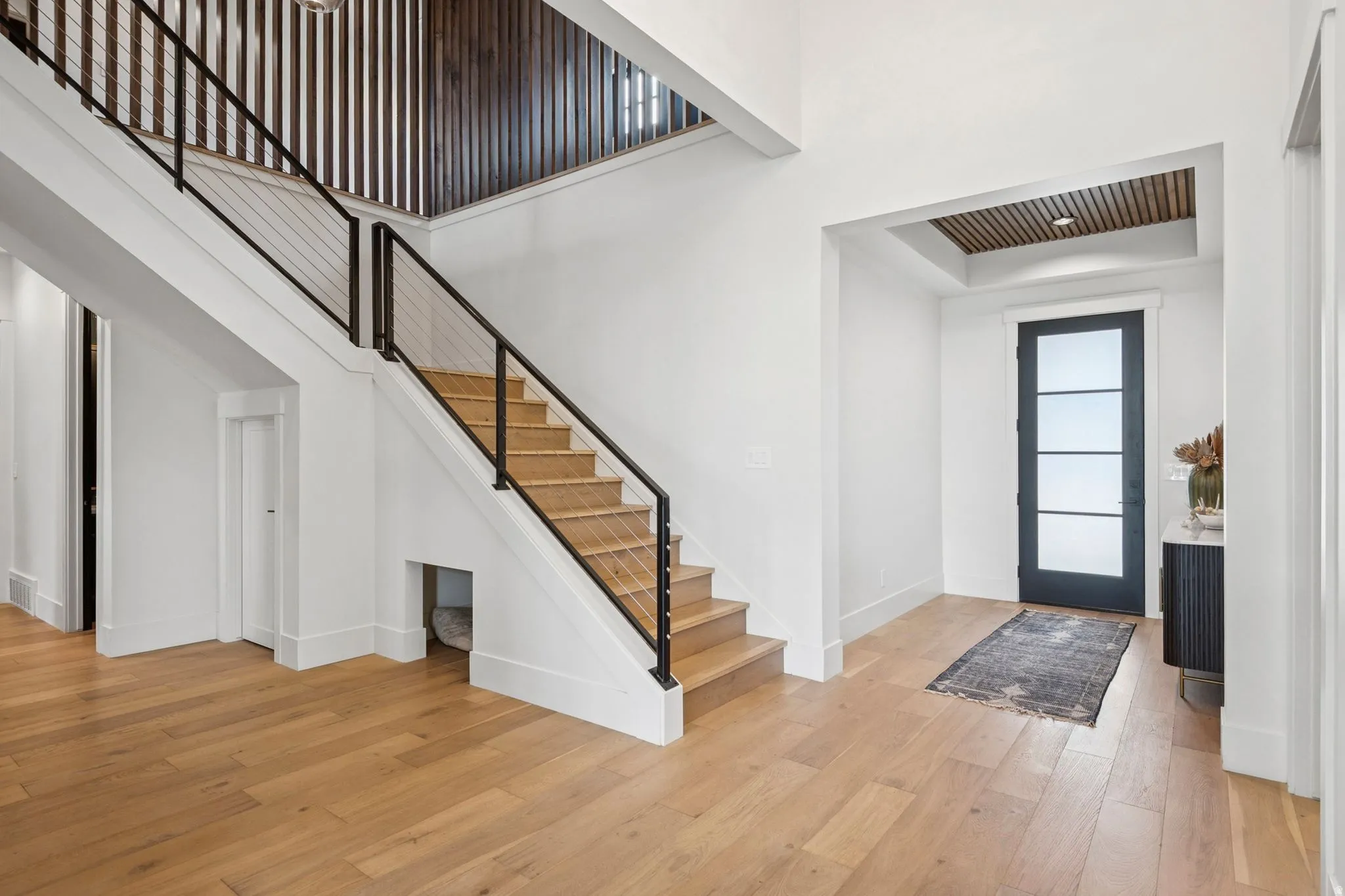 Slatted wood ceiling in entry with designer staircase surround.