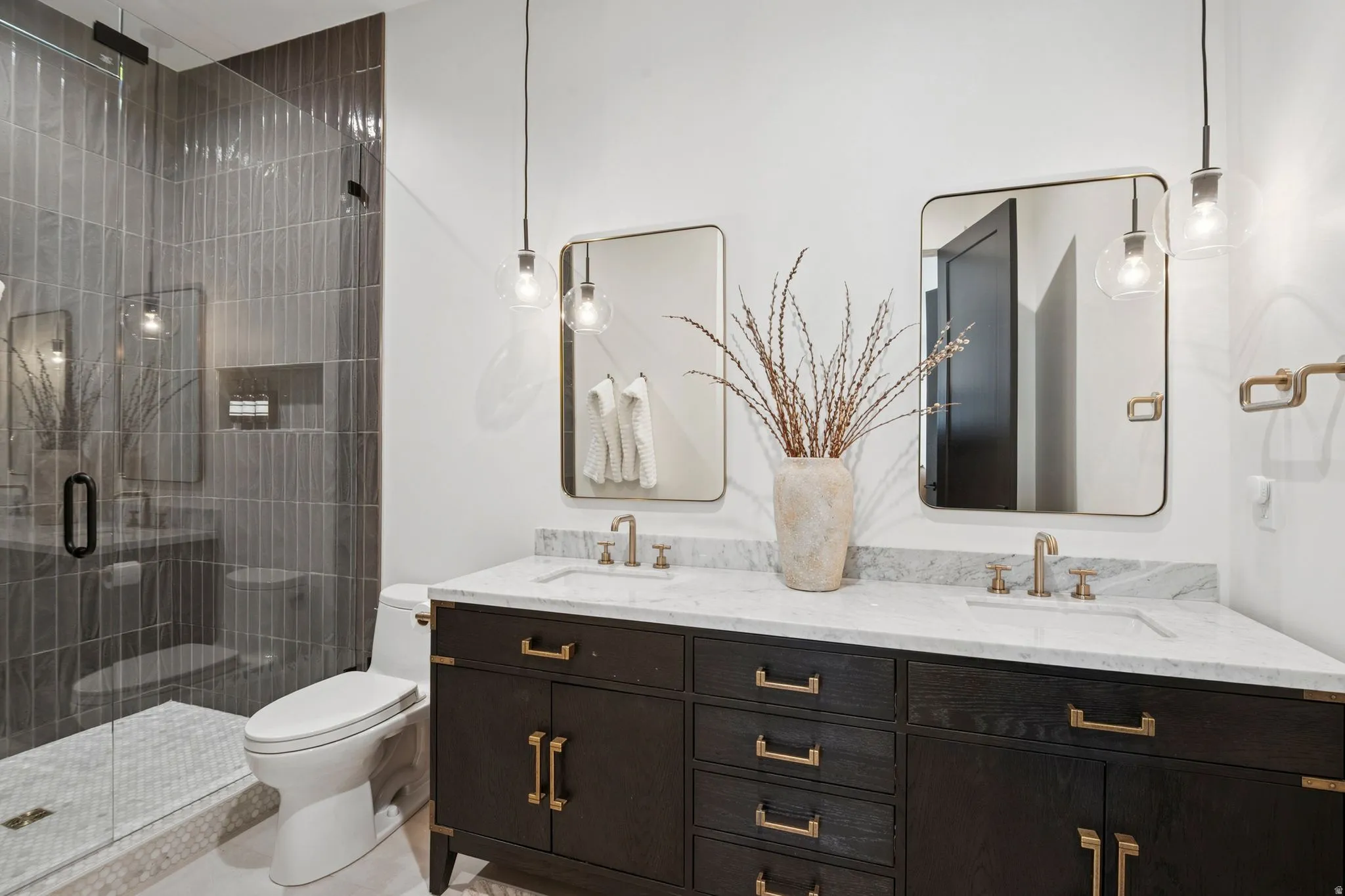 Casita bath featuring dual vanity and luxurious floor to ceiling tile shower with Brizo plumbing fixtures and designer lighting.