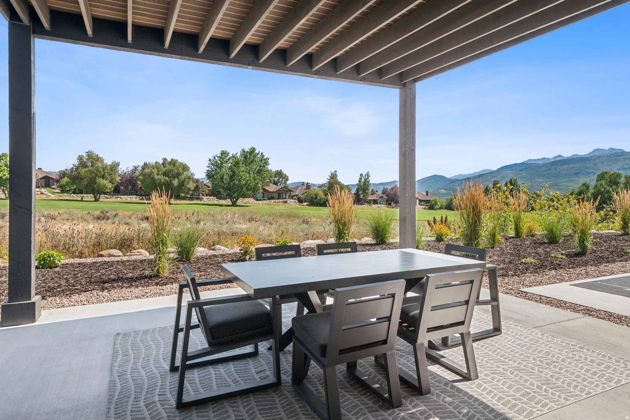Covered patio with a slatted pergola ceiling, gas hook ups for a BBQ, and stunning views.