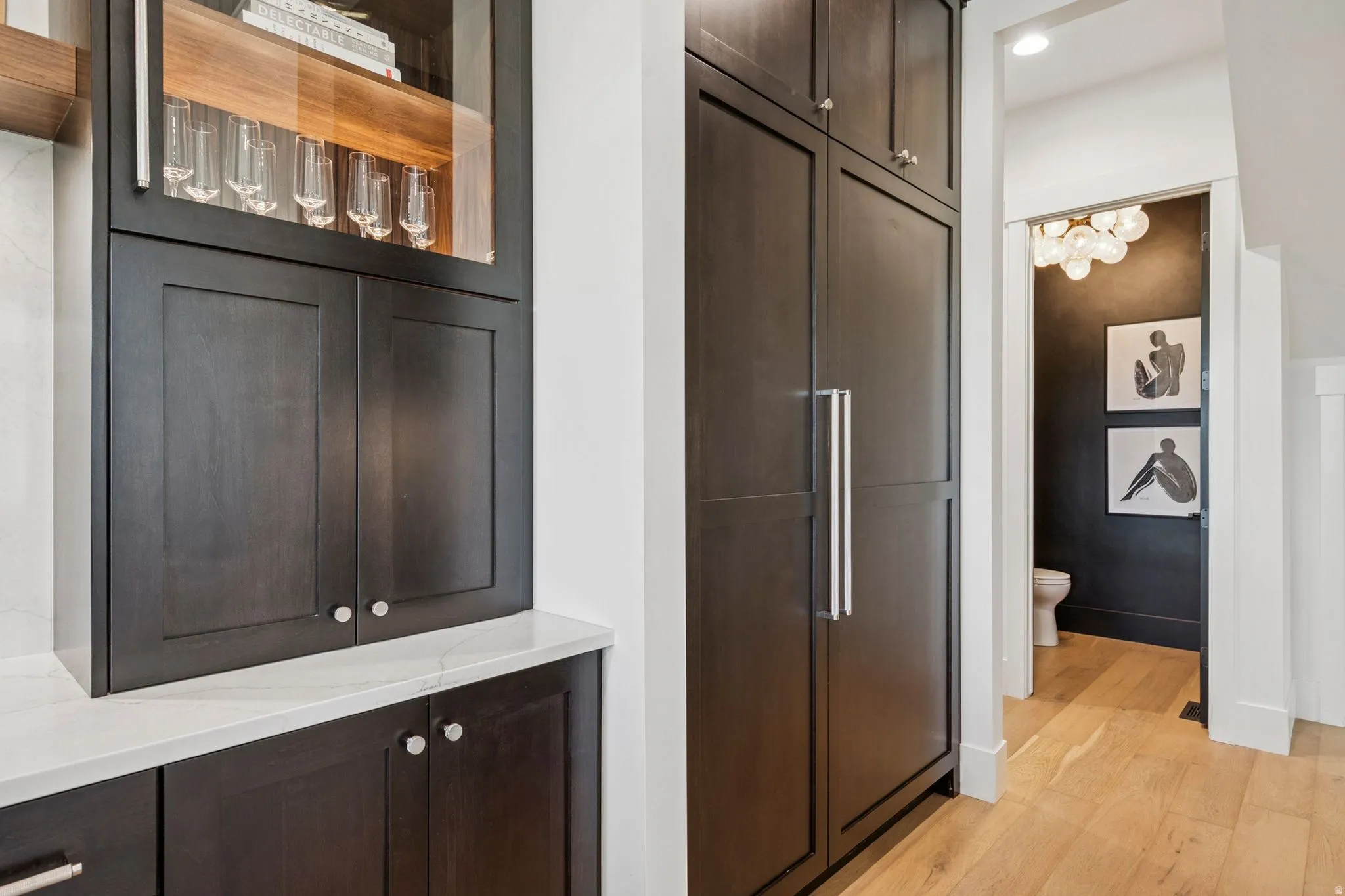 Floor to ceiling cabinets with under-cabinet lighting and a 54" Sub-Zero paneled refrigerator/freezer.