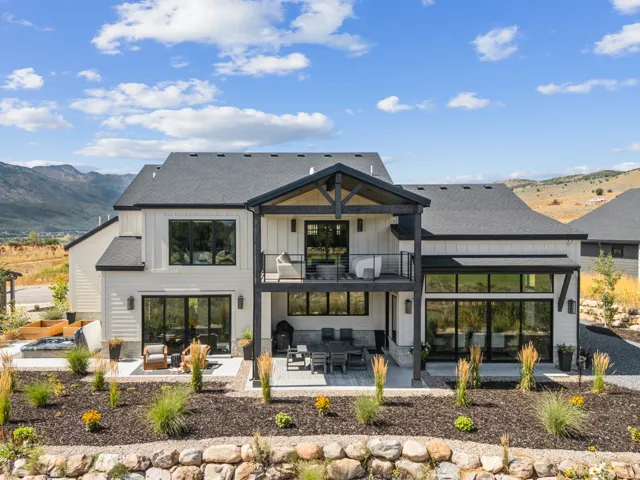 Contemporary 2-story home on golf course featuring covered deck and patio.