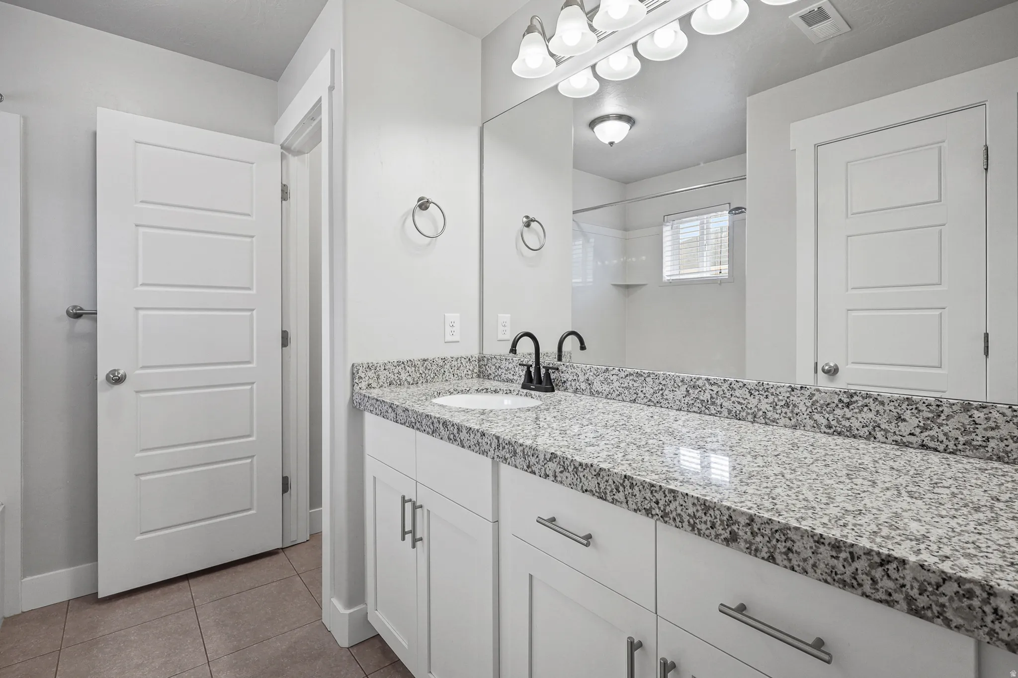 Primary bathroom feat. granite countertops and large counter space.