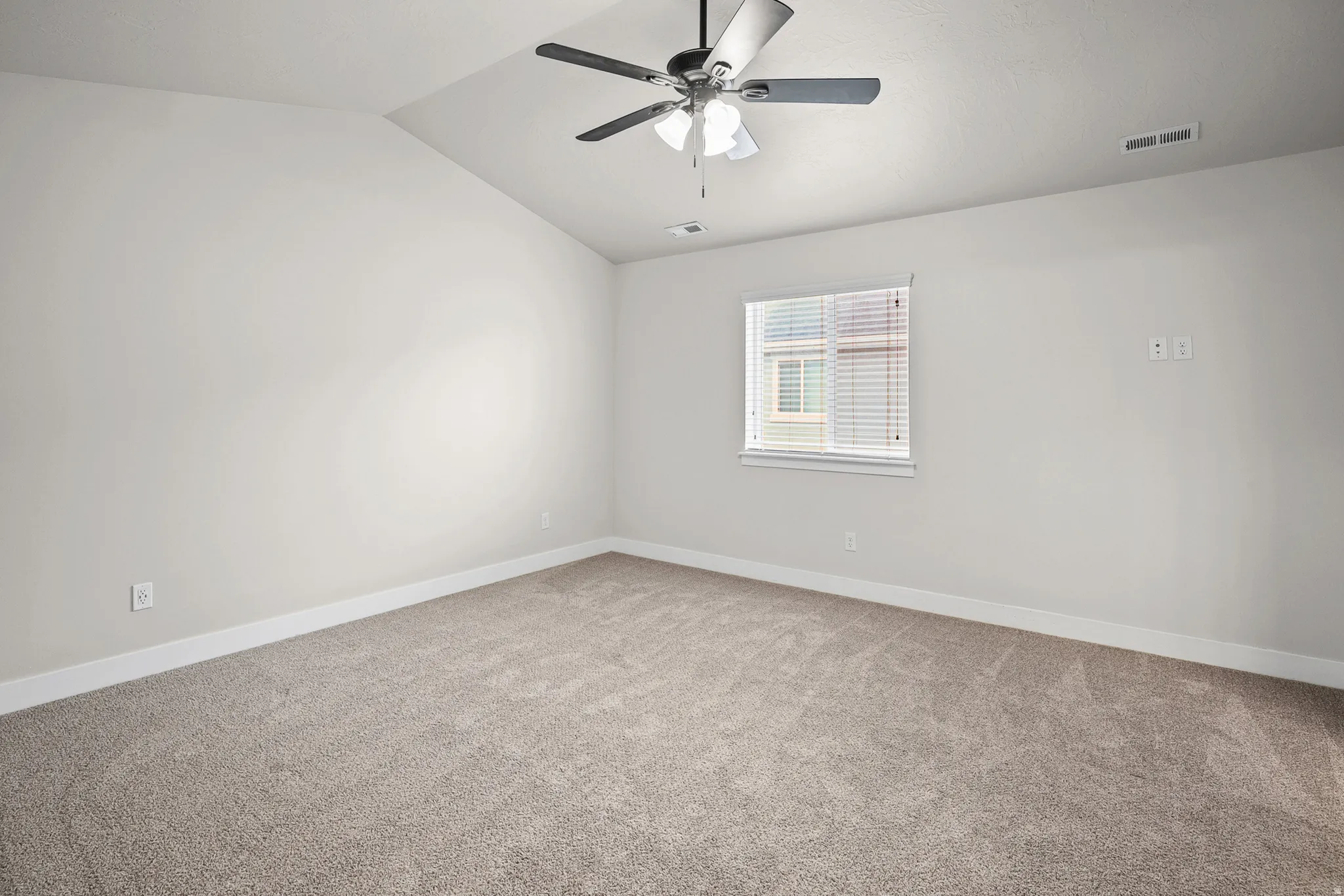 Primary bedroom feat. new carpet and vaulted ceilings