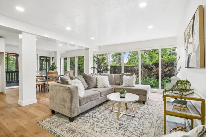 Expansive living area featuring wood-finish flooring, recessed lighting, and abundant natural light from numerous windows