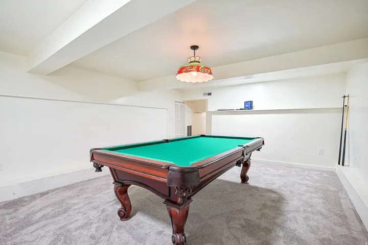Finished room featuring recessed lighting, a built-in display shelf, and light gray carpeting