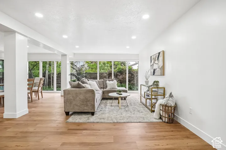 Open-concept living space featuring wood-finish flooring, recessed lighting, and expansive windows
