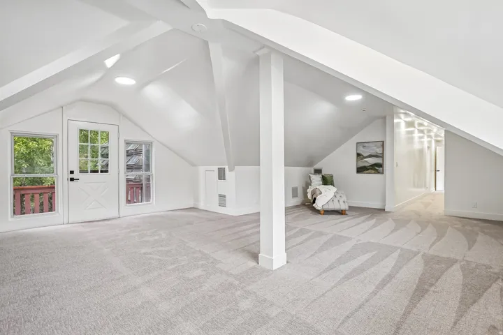 Expansive attic space featuring vaulted ceilings and recessed lighting