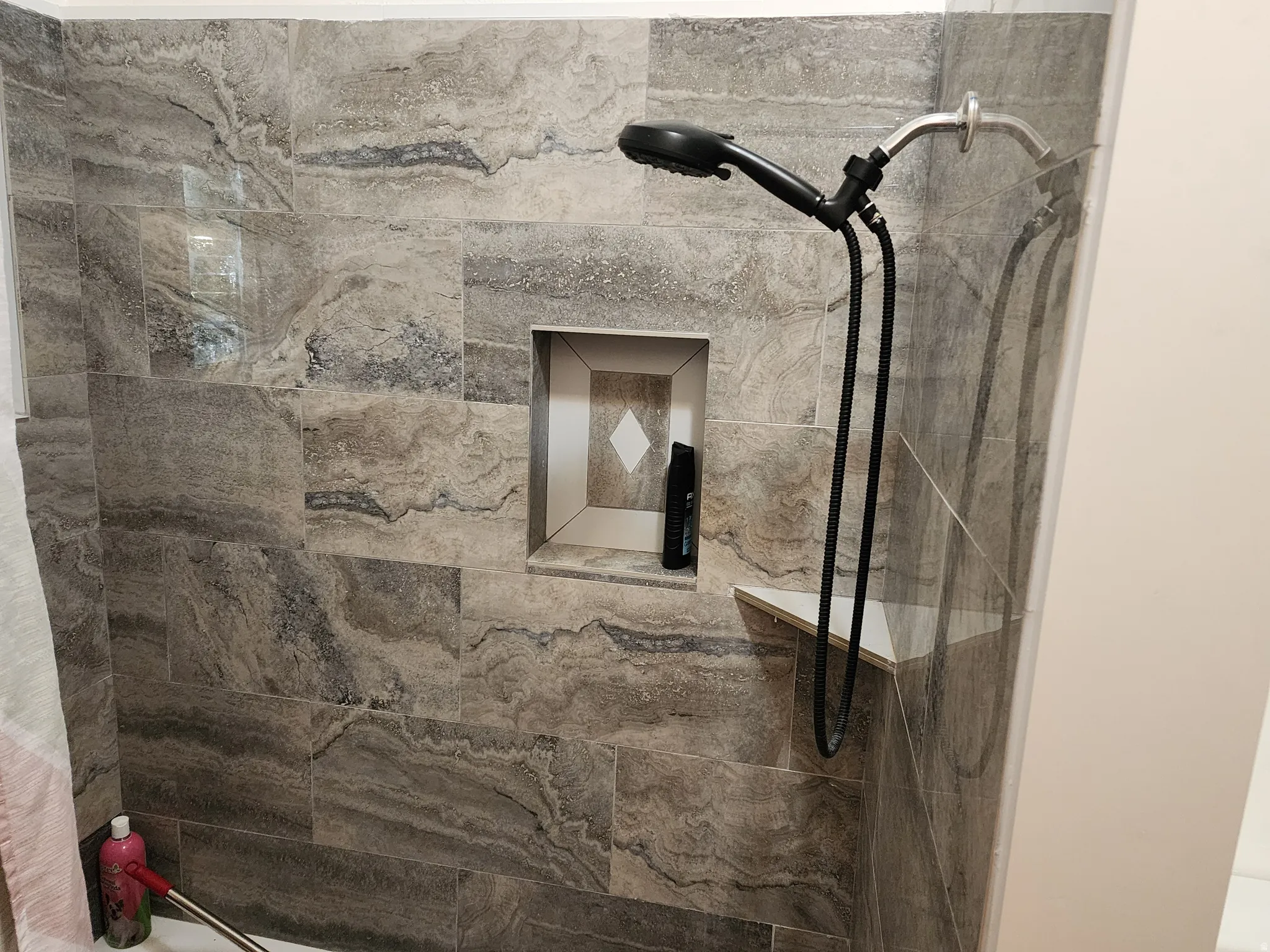 Shower enclosure featuring large format stone-look tile walls