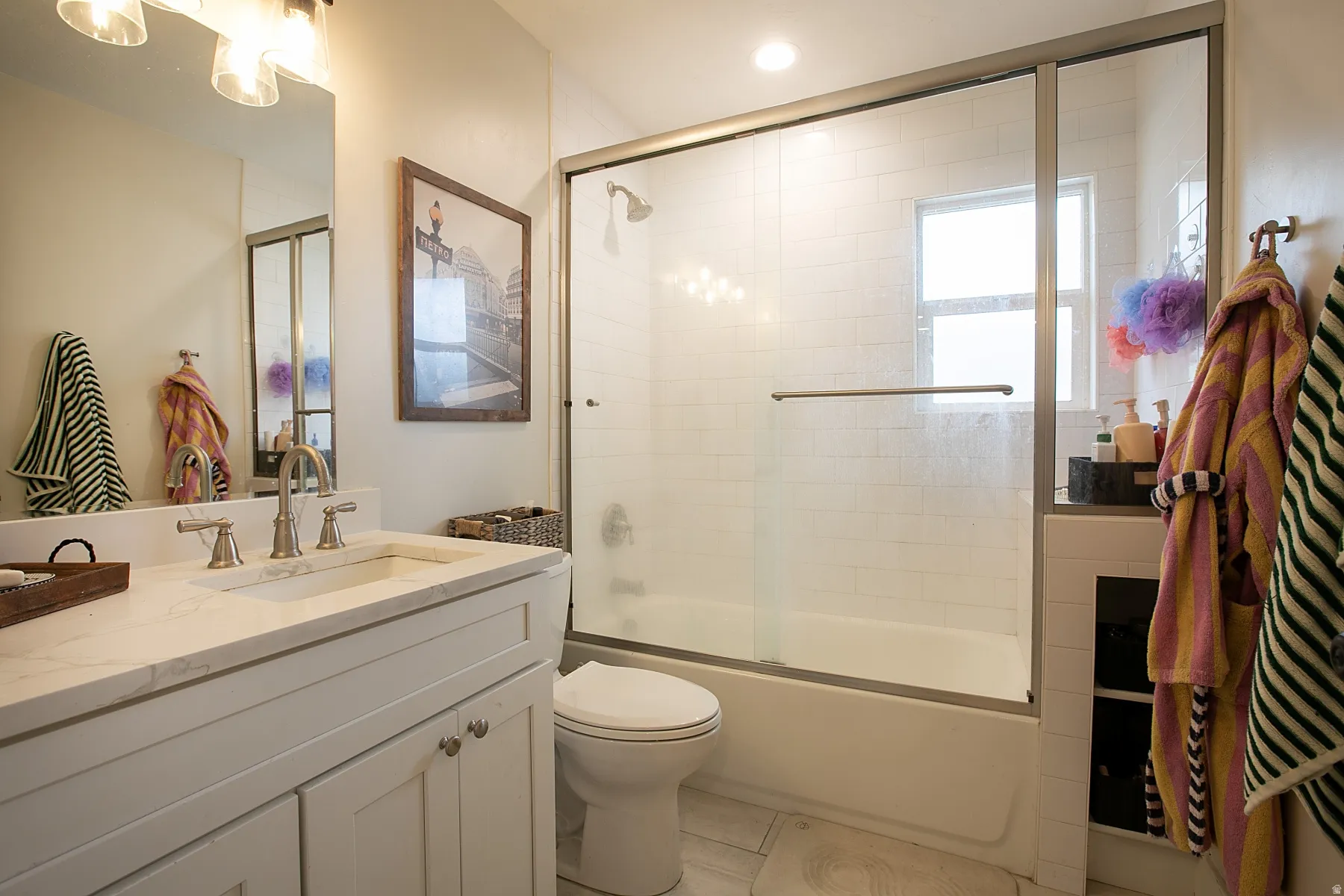 Bathroom featuring vanity, enclosed tub / shower combo, light tile patterned flooring, and recessed lighting
