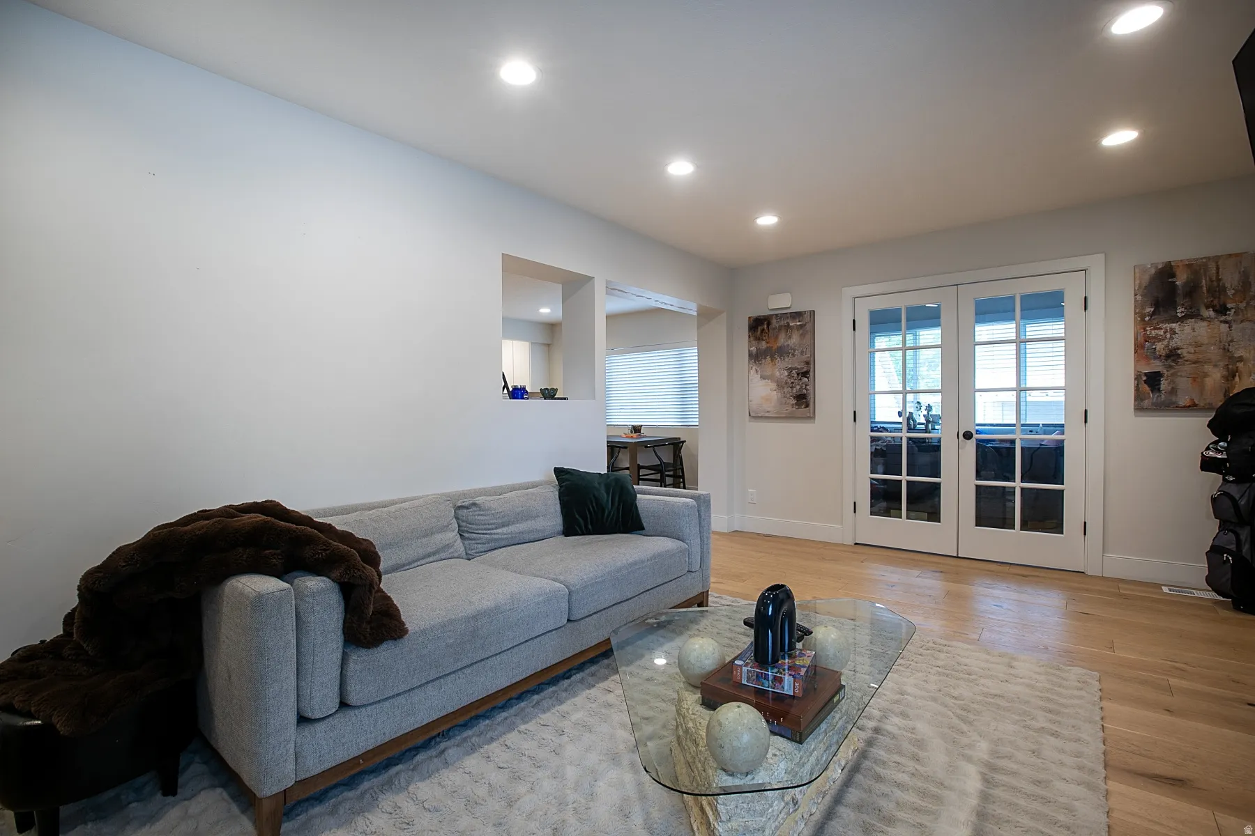 Living room featuring french doors, recessed lighting, and light wood-style floors