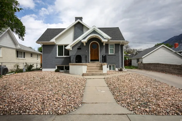 Bungalow-style home featuring brick siding, a chimney, and a shingled roof