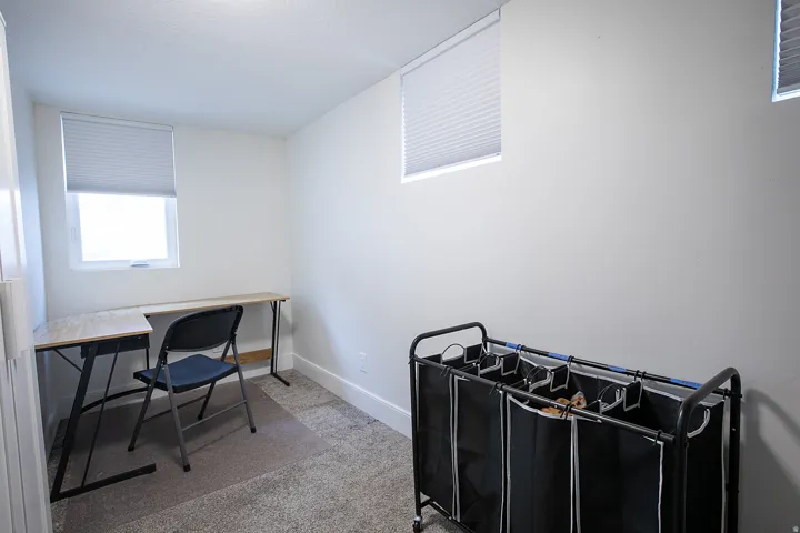 Home office with light carpet and baseboards