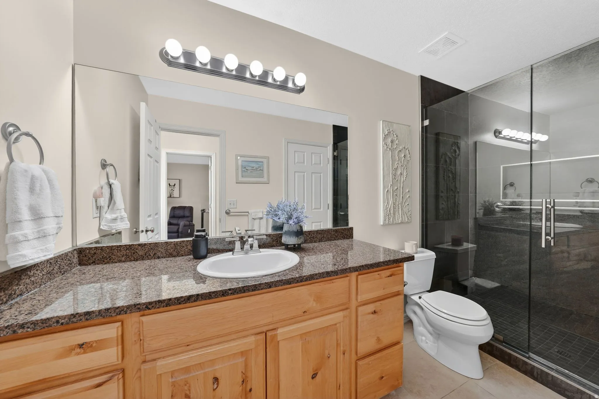 Bathroom with vanity, a stall shower, and light tile patterned flooring