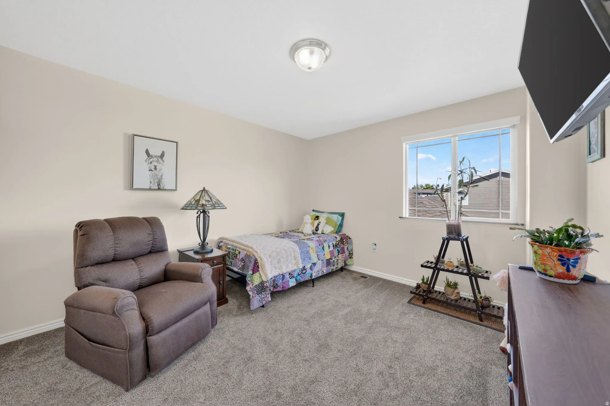 Bedroom with light colored carpet and baseboards
