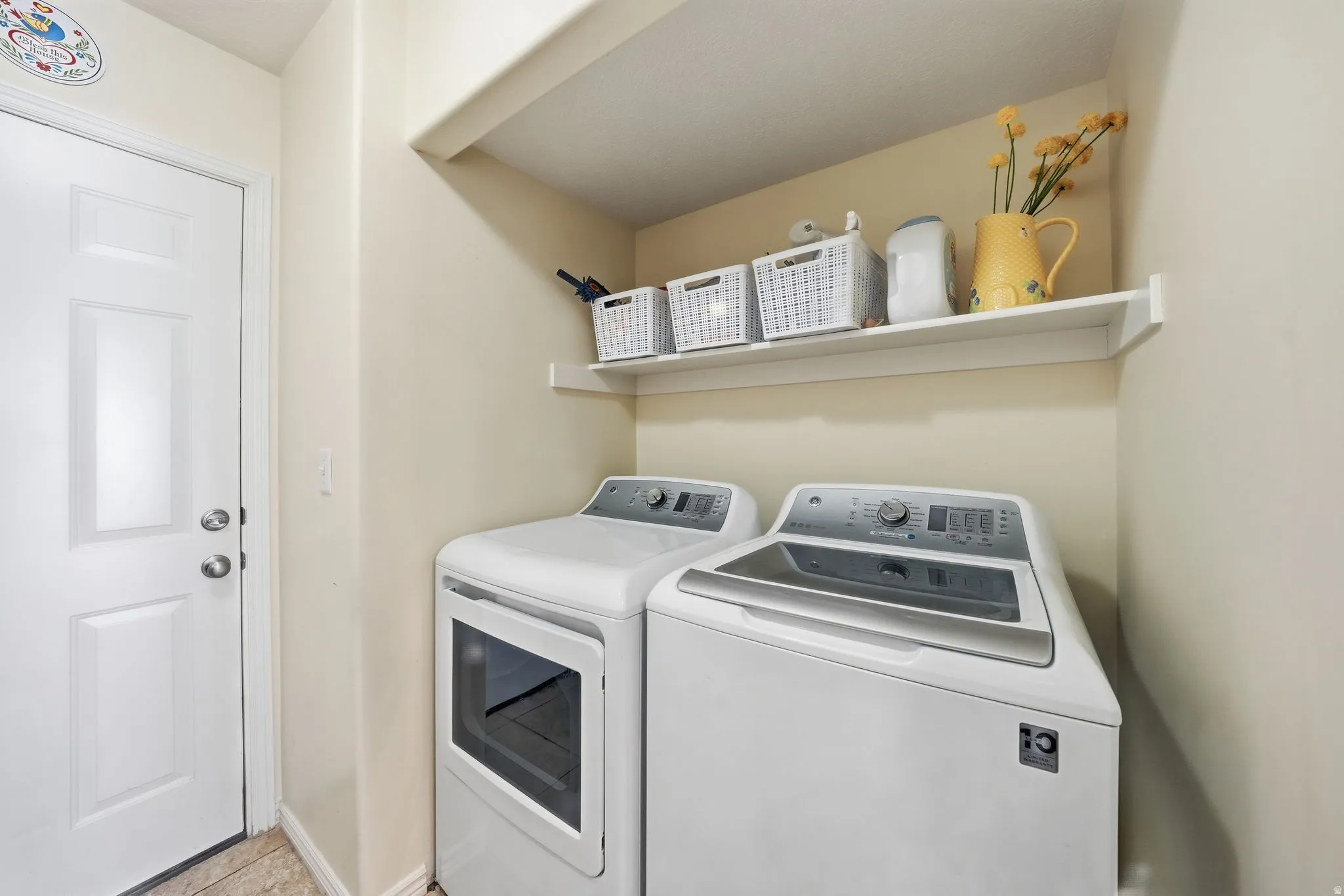 Laundry area featuring separate washer and dryer and baseboards