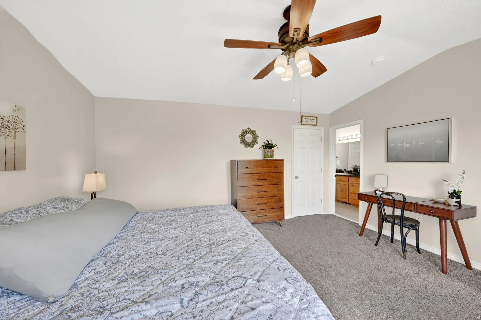 Bedroom featuring vaulted ceiling, light carpet, and ceiling fan