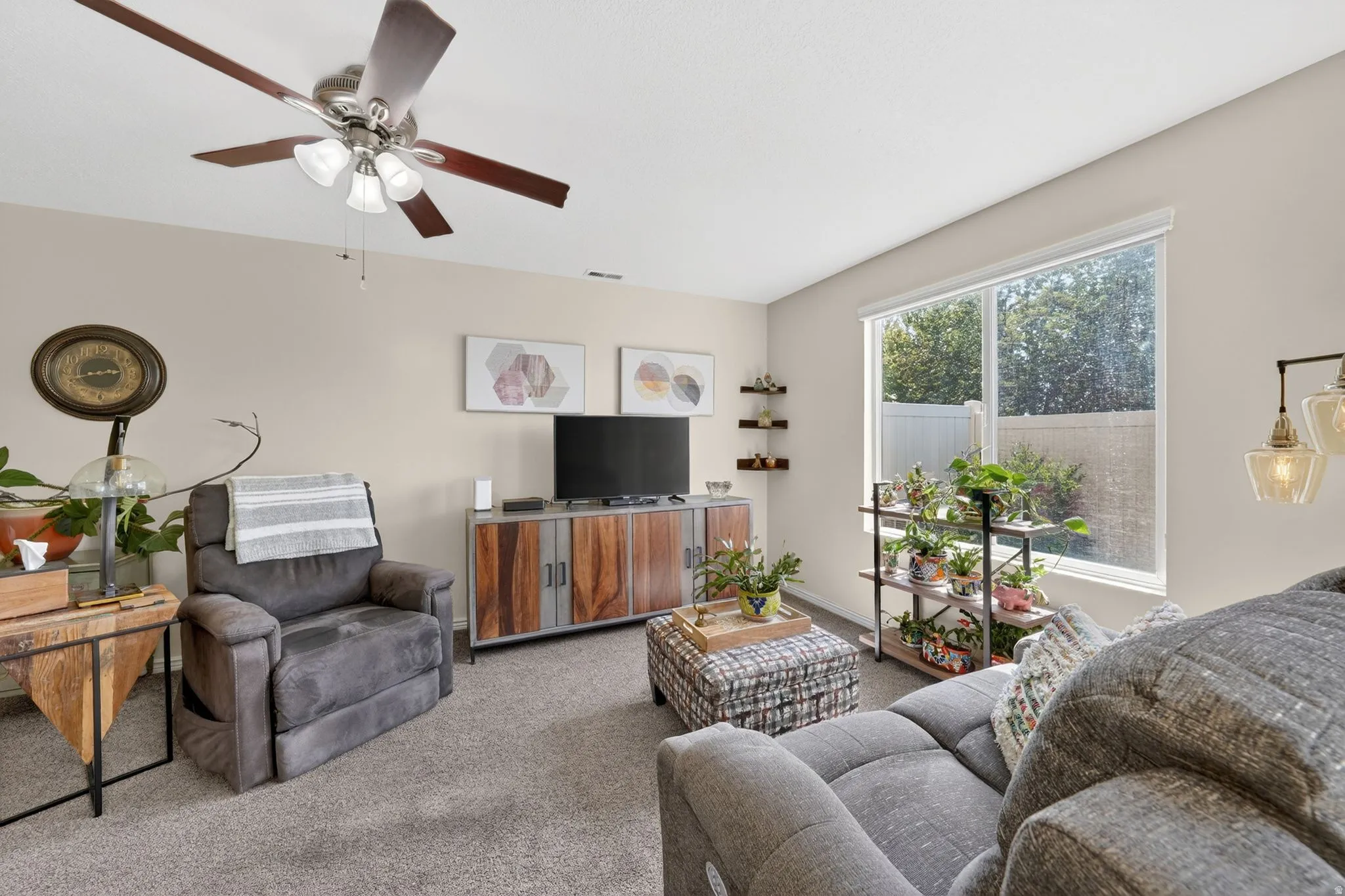 Carpeted living room with ceiling fan