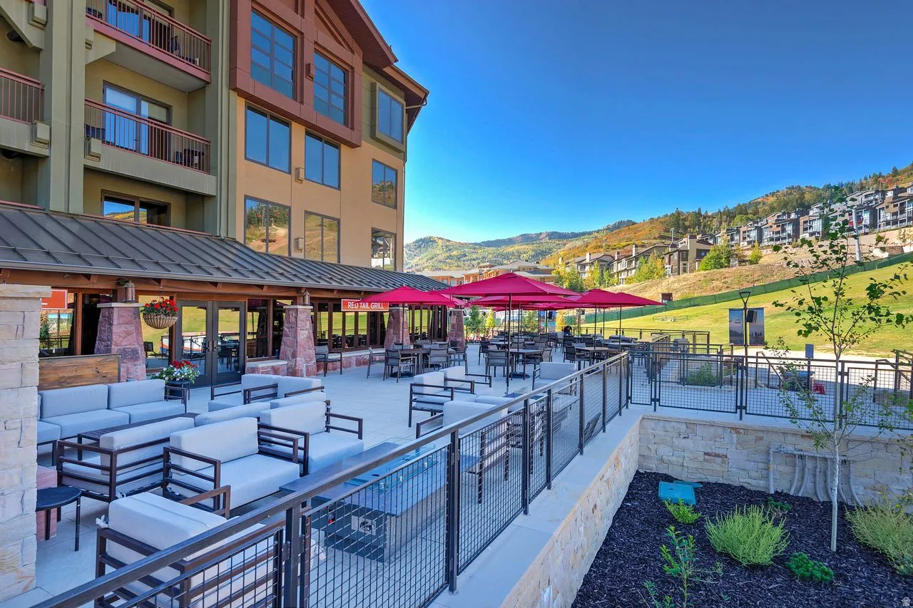 Expansive outdoor patio featuring multiple seating areas, a covered dining space, and mountain scenery