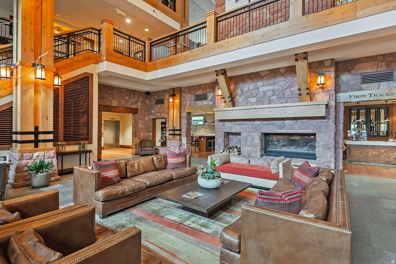 Two-story stone wall featuring a built-in fireplace with a hearth