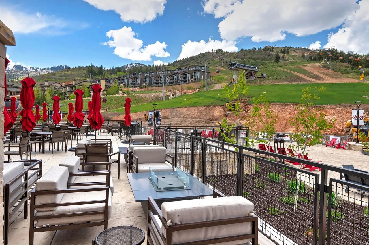 Expansive outdoor patio area featuring multiple seating arrangements and a fire pit table