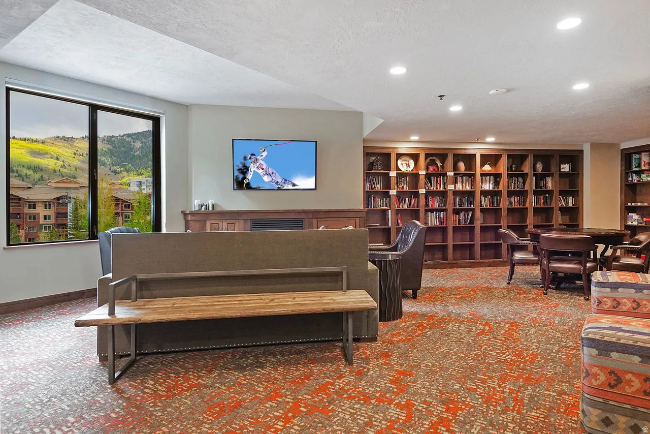 Expansive common area featuring a large window, built-in shelving, recessed lighting, and a decorative fireplace