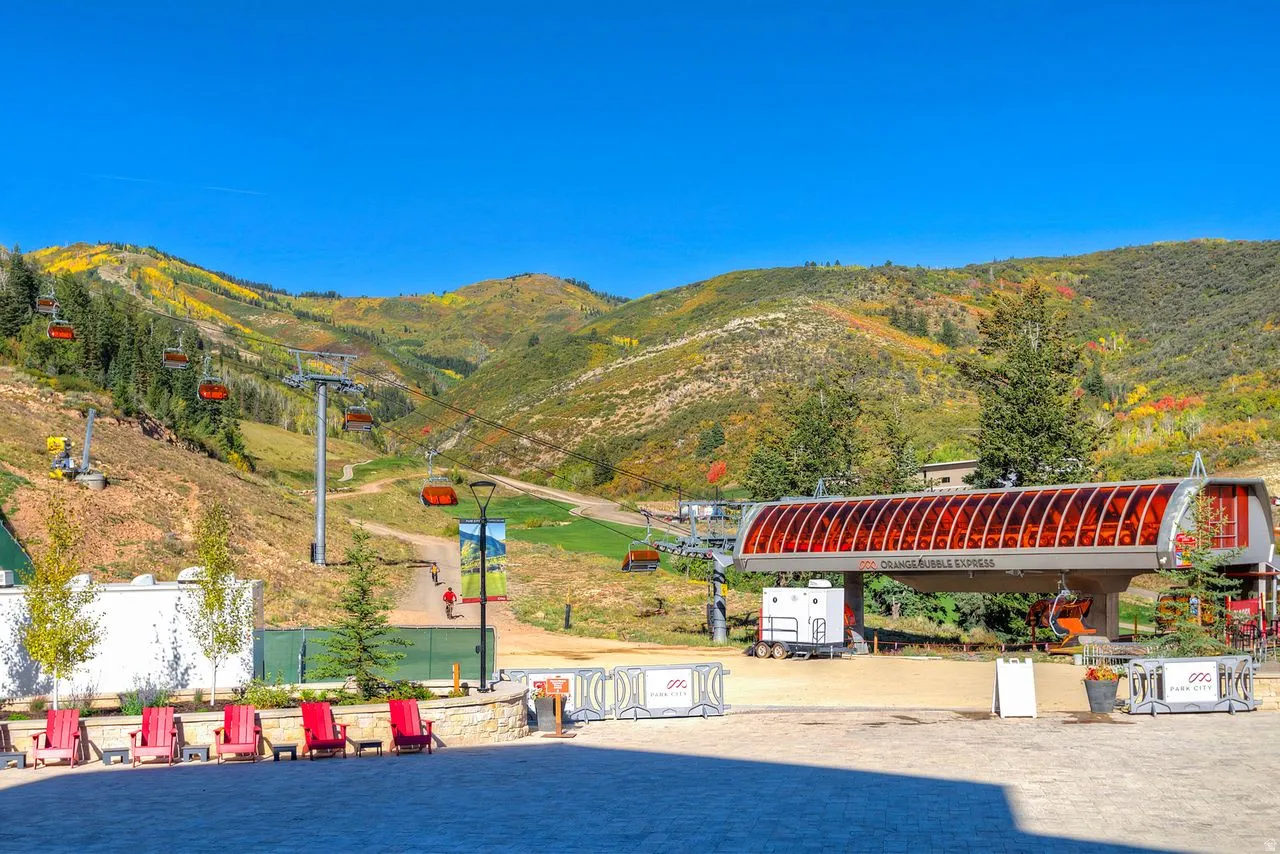 Ski lift station with an integrated covered boarding area, surrounded by paved and stone-edged hardscaping