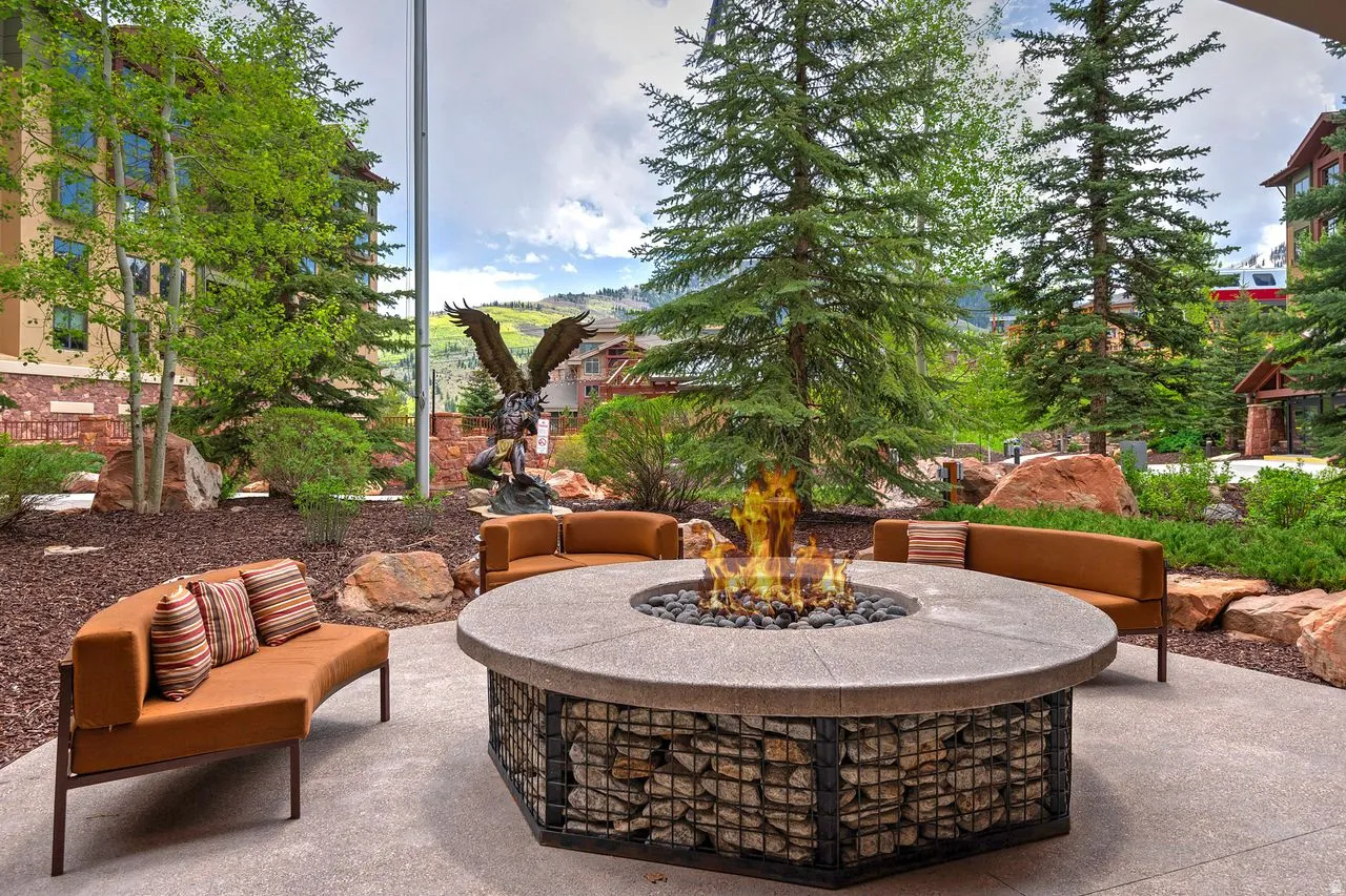Outdoor patio space featuring a circular fire pit with a stone base, a gabion-style stone enclosure, and a concrete top