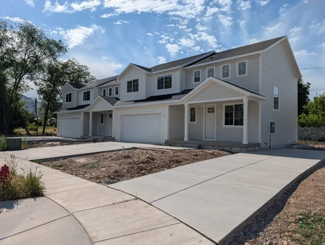 Contemporary multi-unit dwelling with light-colored siding and dark shingle roofing