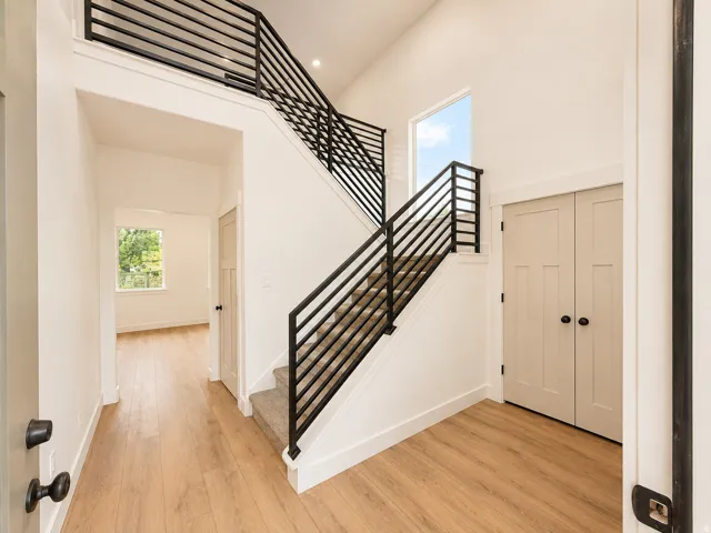 Modern staircase with black metal horizontal railings and carpeted treads