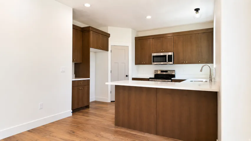 Kitchen featuring wood-finish flooring, recessed lighting, and a kitchen island with a white countertop