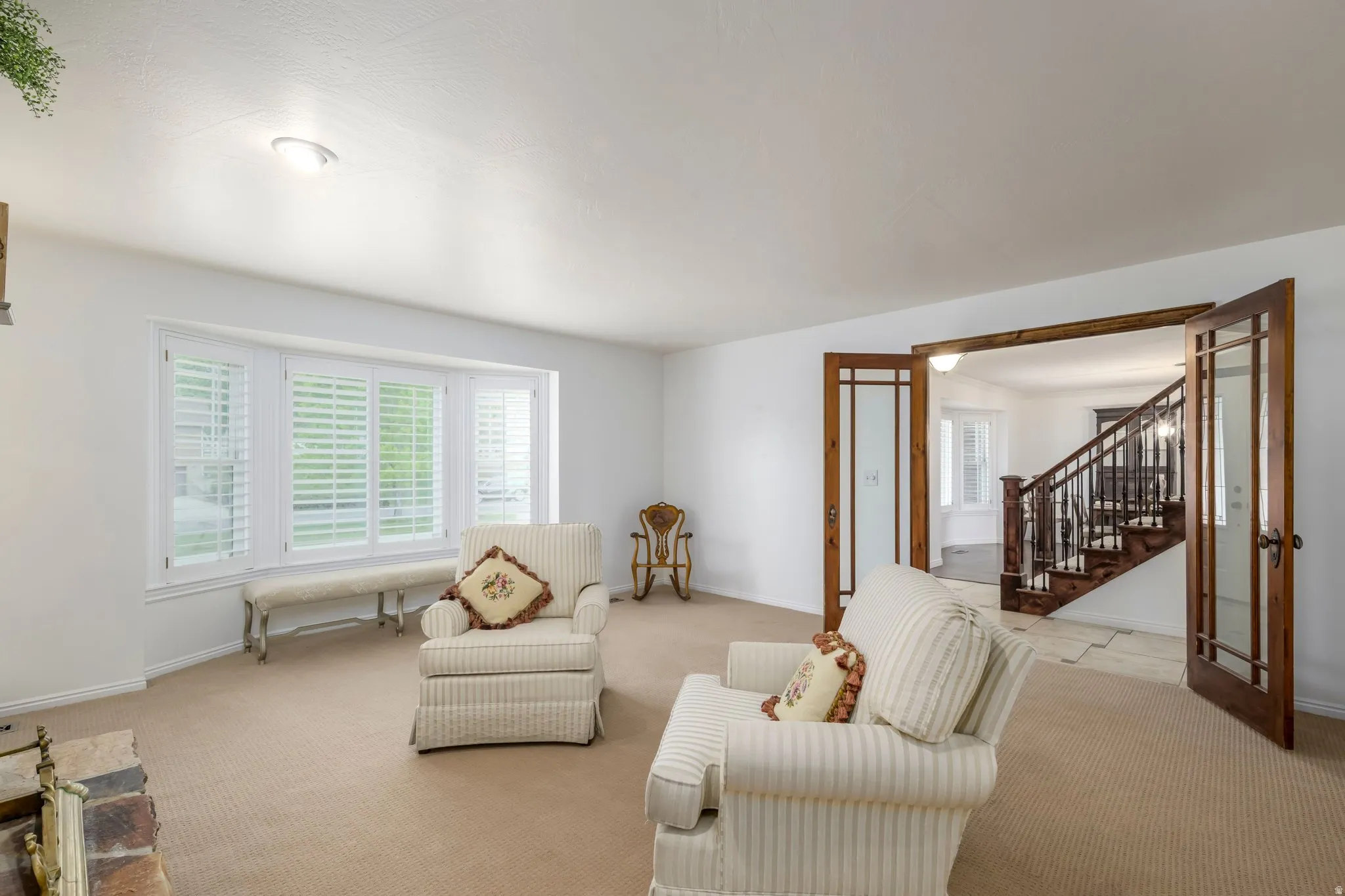 Living area featuring a bay window with plantation shutters