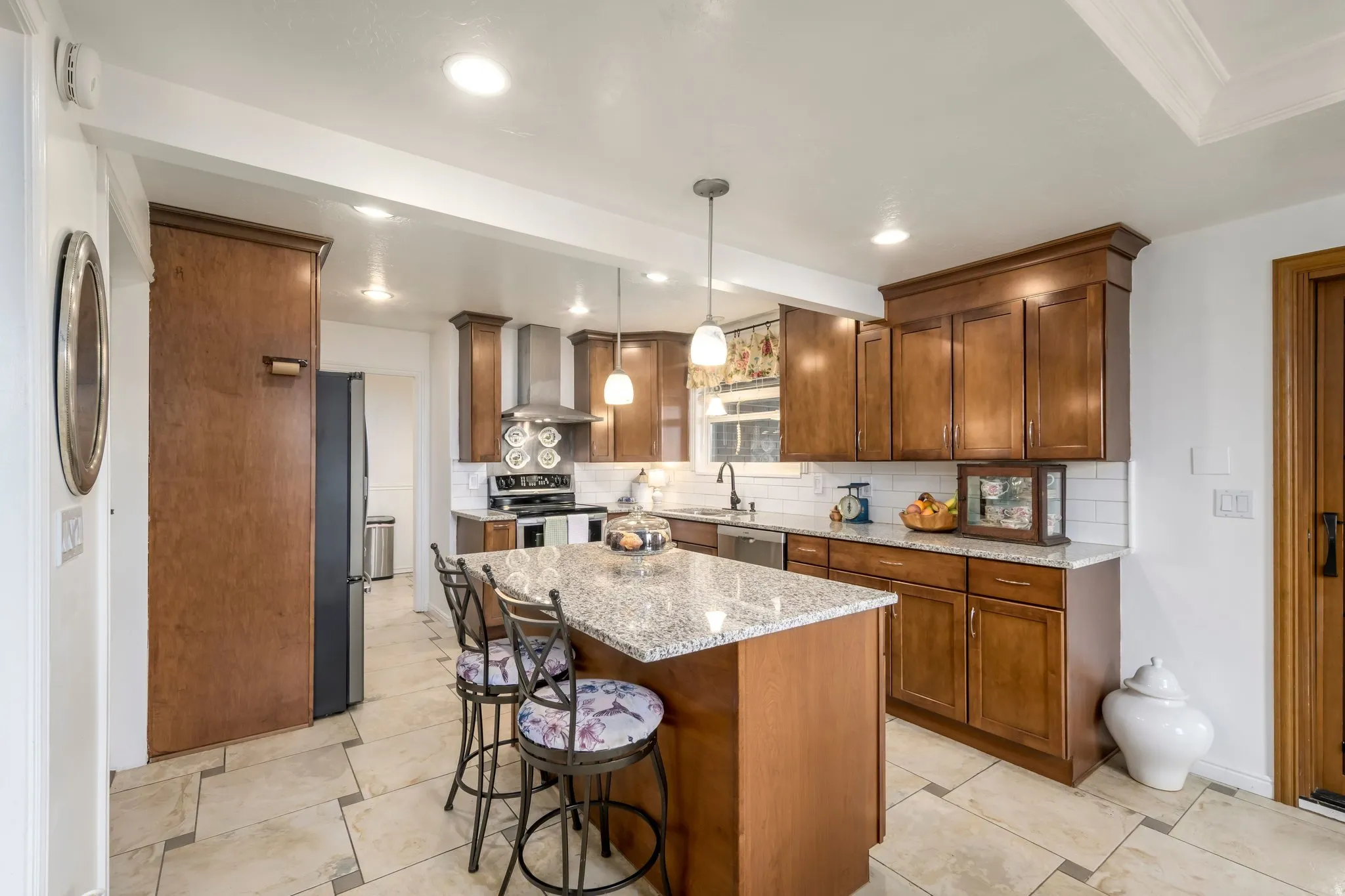Kitchen featuring a central island with a light-toned countertop, wood-finish cabinetry, stainless steel appliances, and recessed lighting