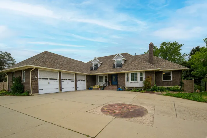 Traditional brick exterior with an attached three-car garage and a concrete driveway
