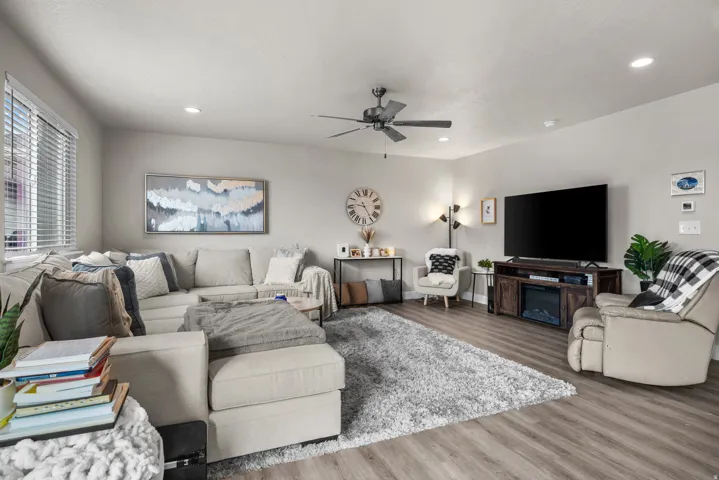 Spacious living area featuring wood-finish flooring, recessed lighting, and a ceiling fan