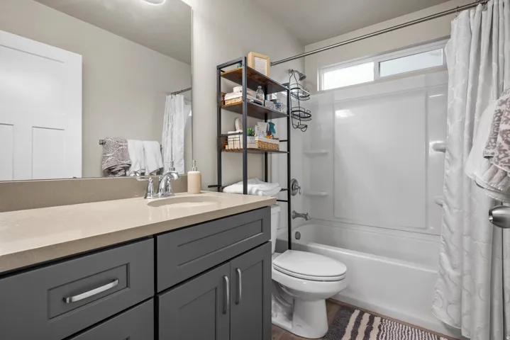 Bathroom featuring a vanity with a light-toned countertop, a rectangular undermount sink, and dark gray cabinetry